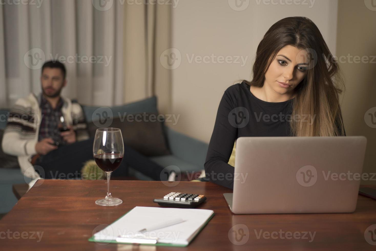 Young couple managing finances, reviewing their bank accounts using laptop computer. Woman and man doing paperwork together, paying taxes online on notebook pc photo