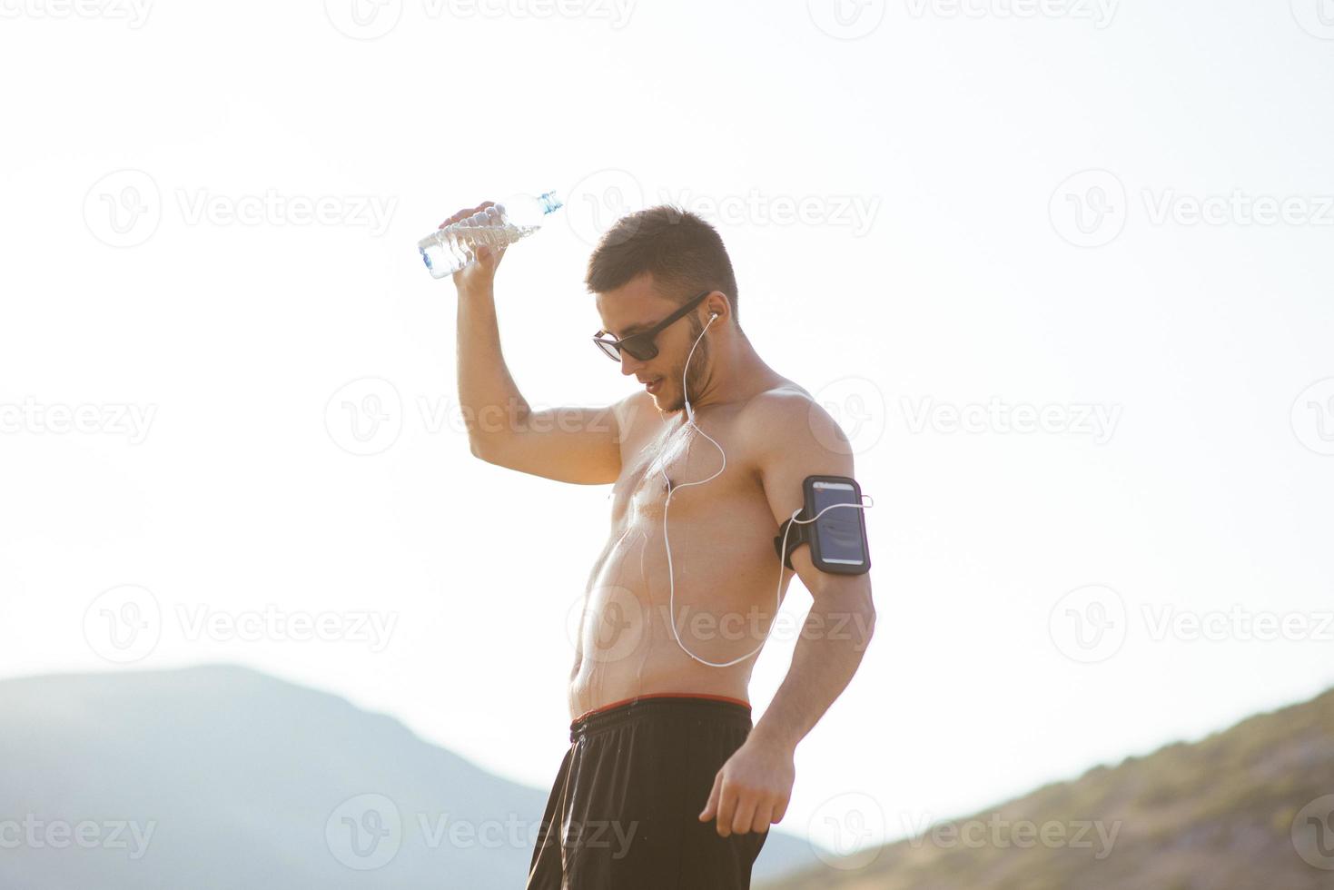 hombre caucásico bebiendo agua con los ojos cerrados después de los ejercicios foto