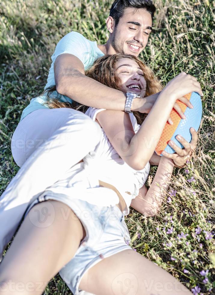 pareja jugando fútbol americano en un caluroso día de verano. sesión de fotos de pareja jugando al rugby