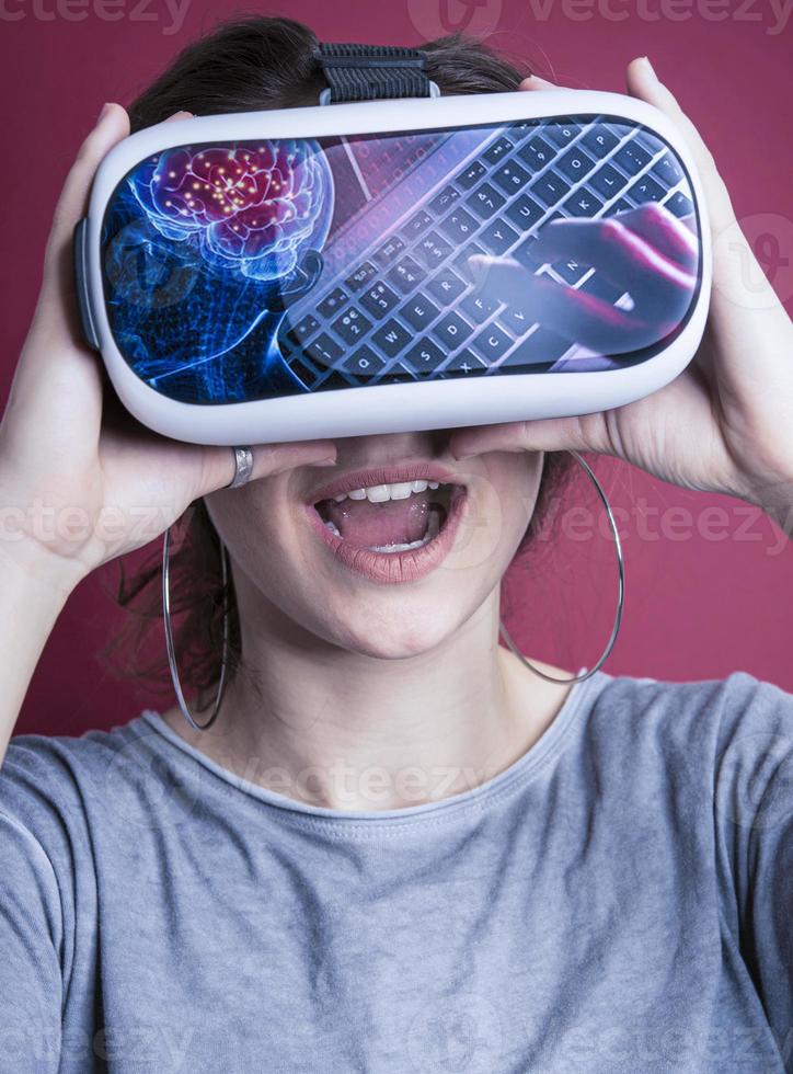 Pretty cute excited female in VR headset looking up and trying to touch objects in virtual reality photo