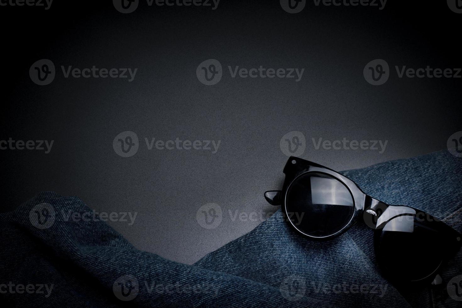 Modern background with jeans and sunglasses, with free space for text. photo