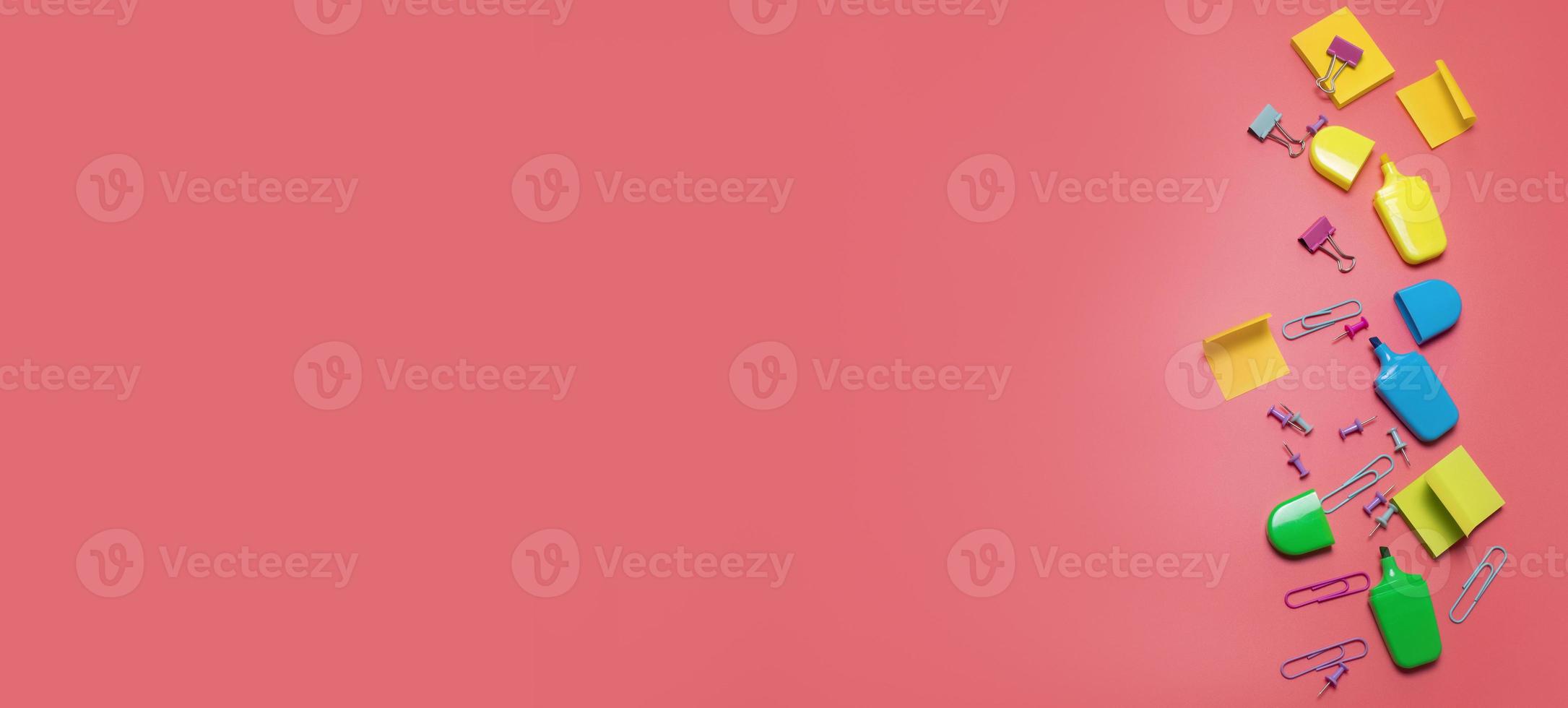 Stationery items on the pink background with free space for text. Creative, colorful background with scool or office supplies. Flatlay with copy space, top view. Markers, paper clips, sticky notes. photo