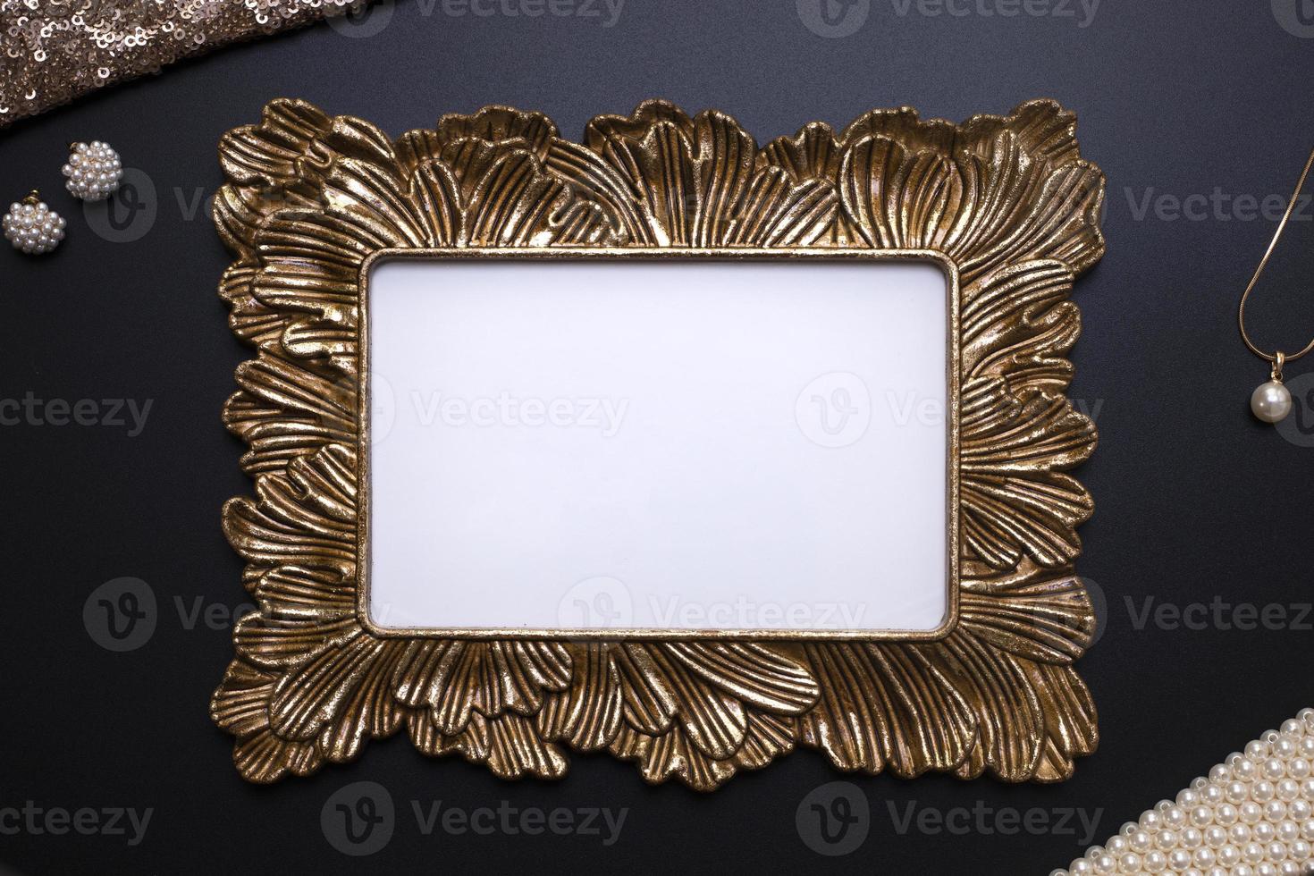 Elegant background, template for text, logo or picture. Golden decorative picture frame and jewellery on the black background. Free space, copy space. photo