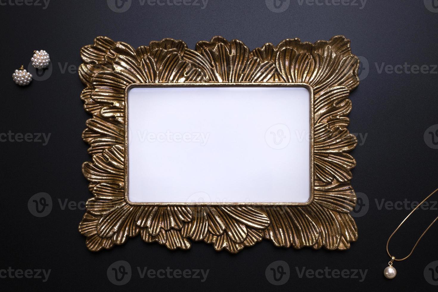 Elegant background, template for text, logo or picture. Golden decorative picture frame and jewellery on the black background. Free space, copy space. photo
