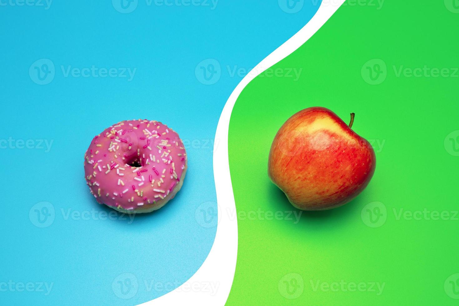 Donut and apple on the blue background. Choosing between apple and donut. photo