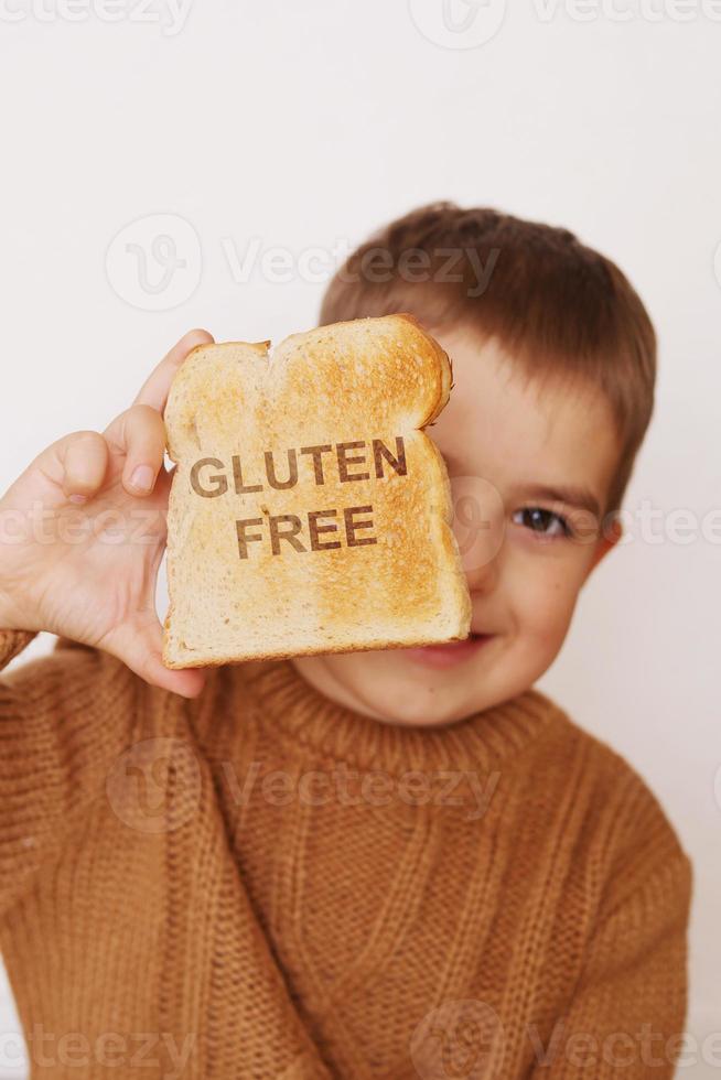 Preschool boy with toasted bread without gluten. Healthy food. Gluten intolerance by children. photo