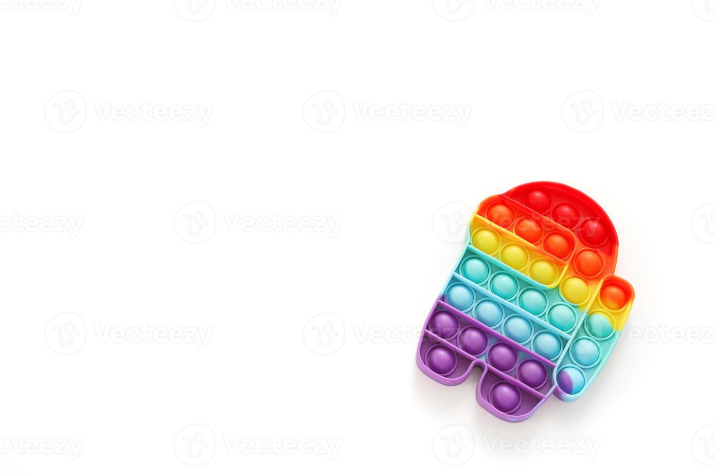 Rainbow Pop it fidget toy on white background. Free space, copy space. Antistress children game. Children's trendy silicone toys pop it to relieve stress and develop hand motor skills. photo