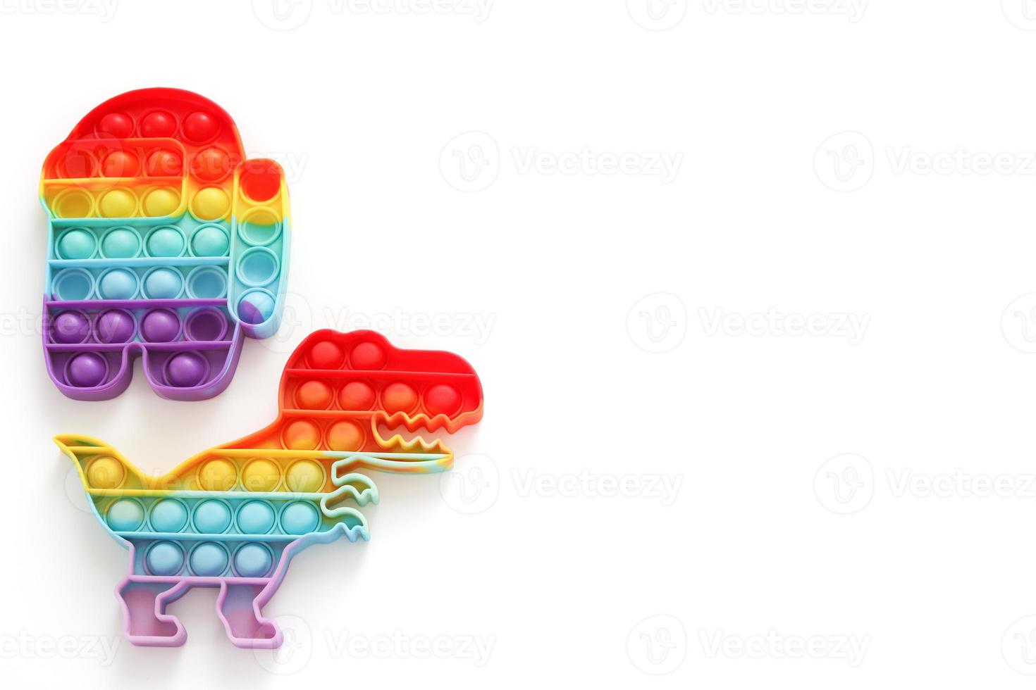 Rainbow Pop it fidget toys on white background. Free space, copy space. Antistress children game. Children's trendy silicone toys pop it to relieve stress and develop hand motor skills. photo