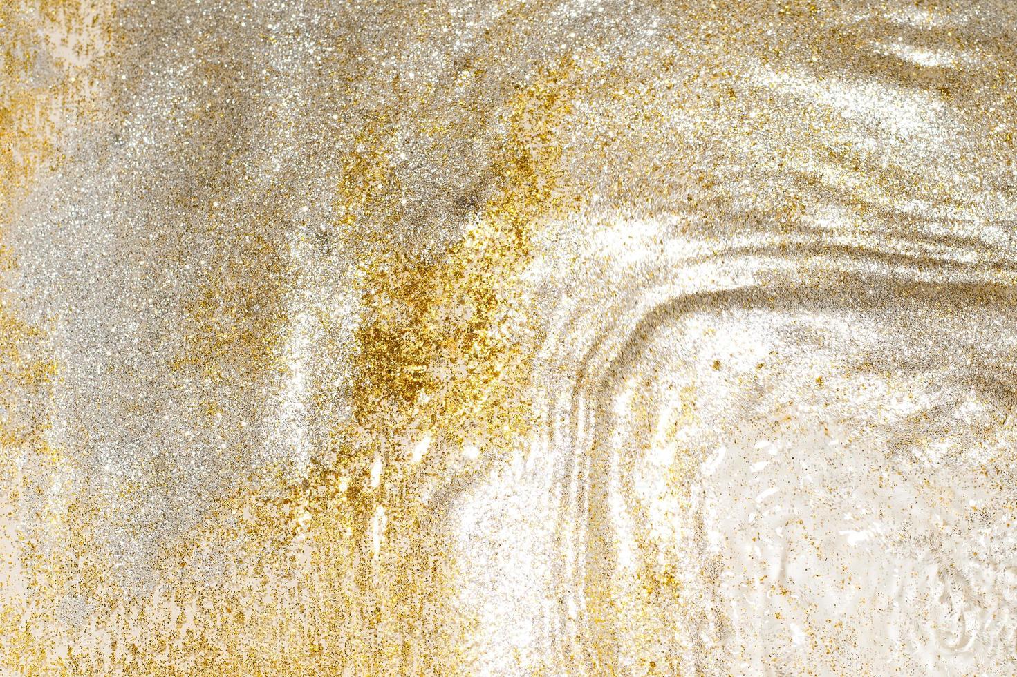 Golden and silver sparkles in water. Glitter and liquid texture. Abstract background with golden an silver particles. Shining celebration background. Festive backdrop for your projects. photo