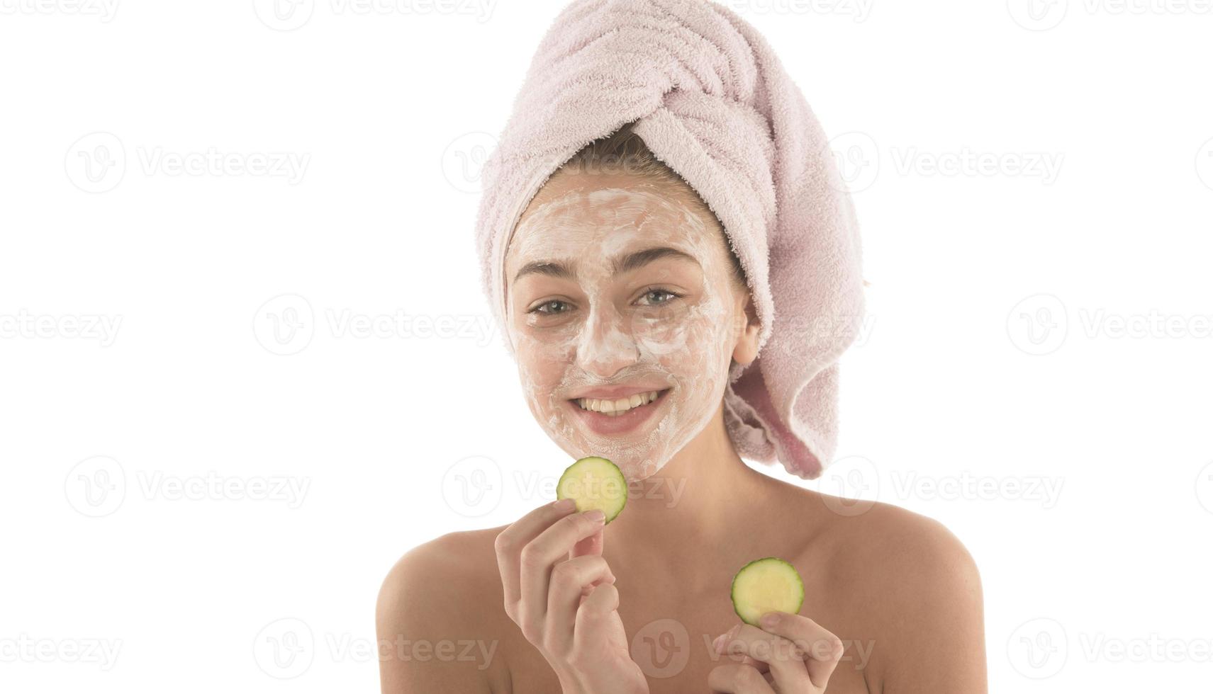 Beautiful woman with eyes closed and white clay facial mask on face isolated on white background photo