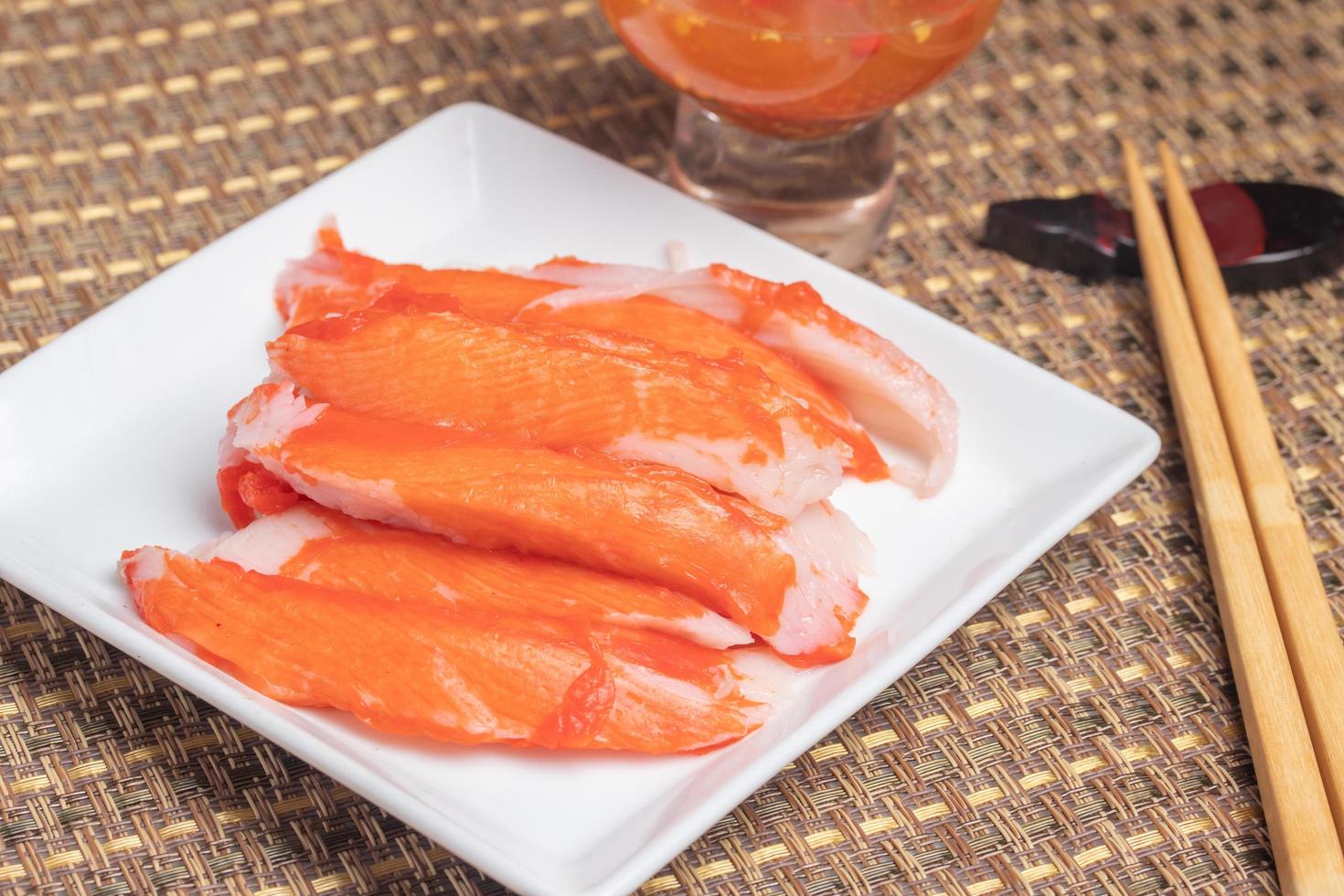 Boiled crab sticks with spicy and sour sauce photo