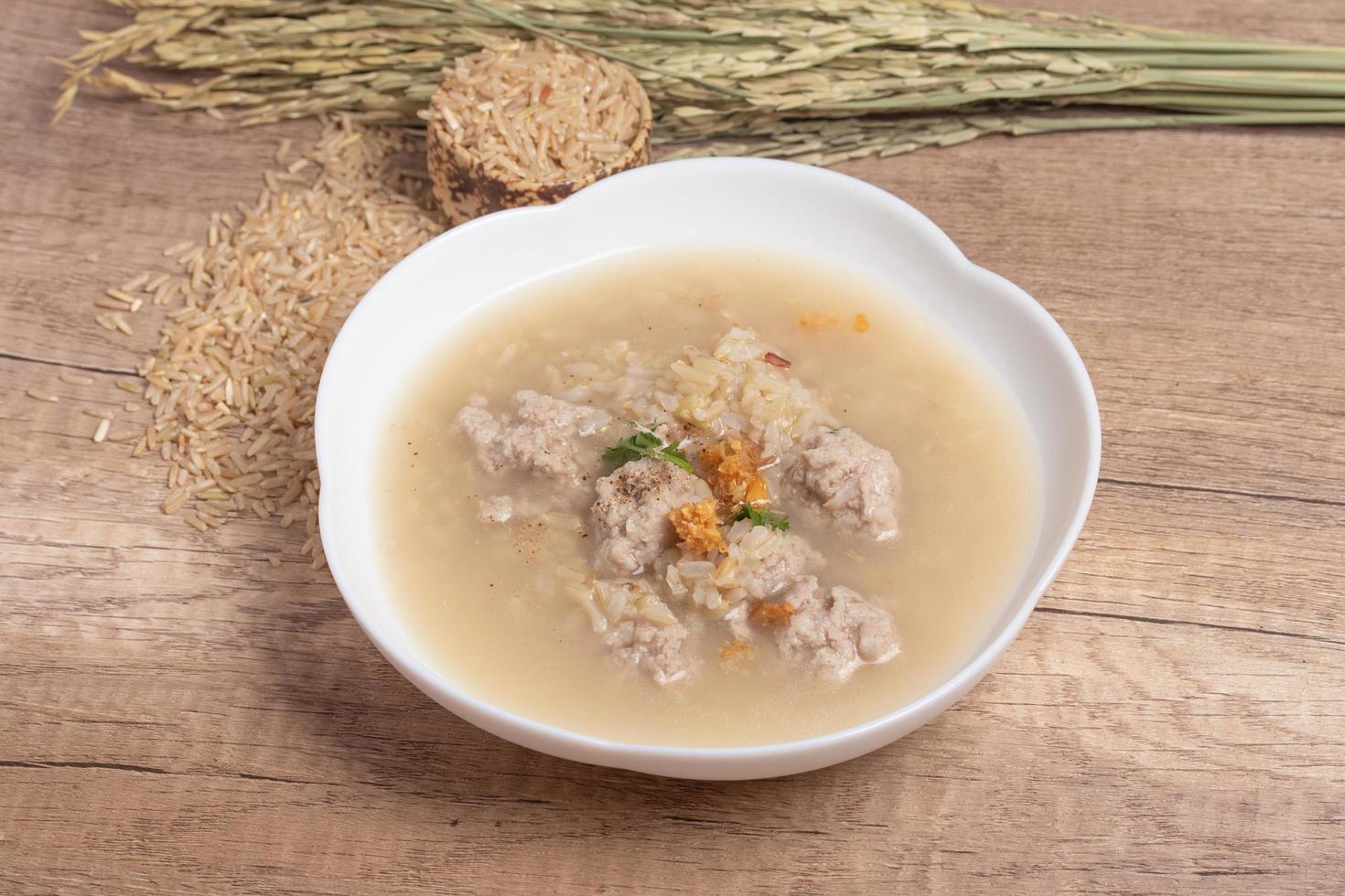 papilla de arroz integral jazmín con carne de cerdo sobre fondo de madera.espacio de copia de alimentos saludables foto