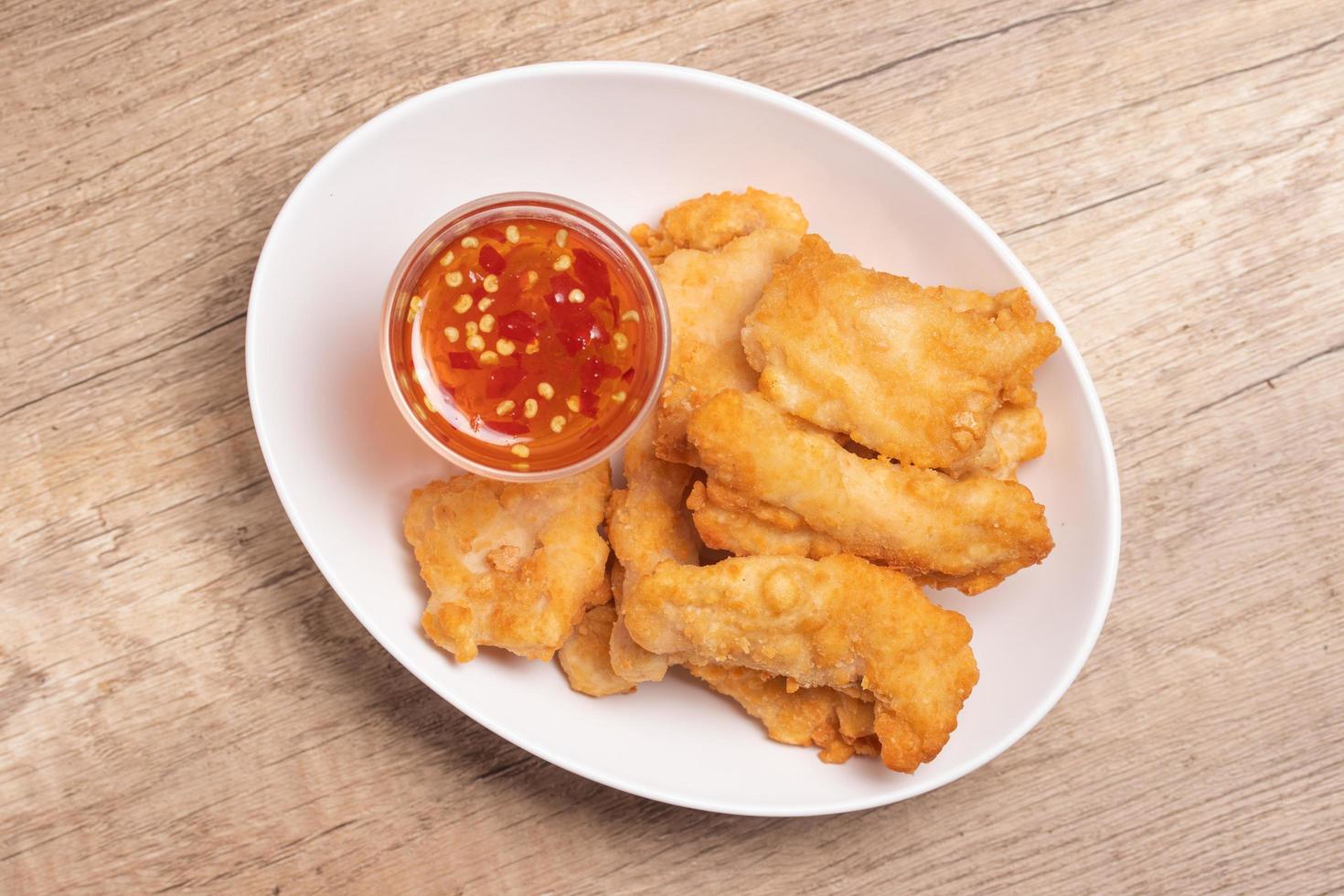 nuggets de pollo frito con salsa en plato blanco foto