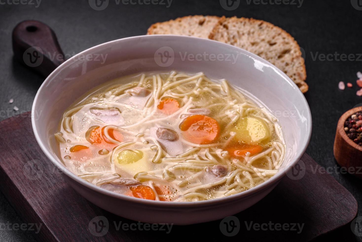 Delicious soup with noodles, chicken and carrots with spices and herbs photo