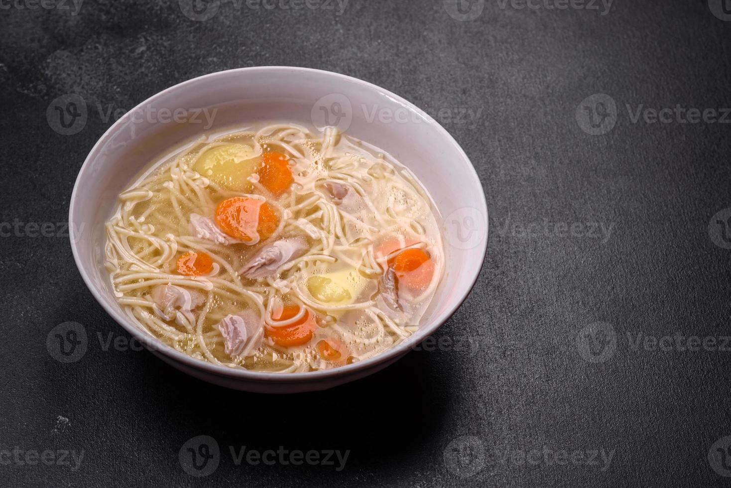 Delicious soup with noodles, chicken and carrots with spices and herbs photo