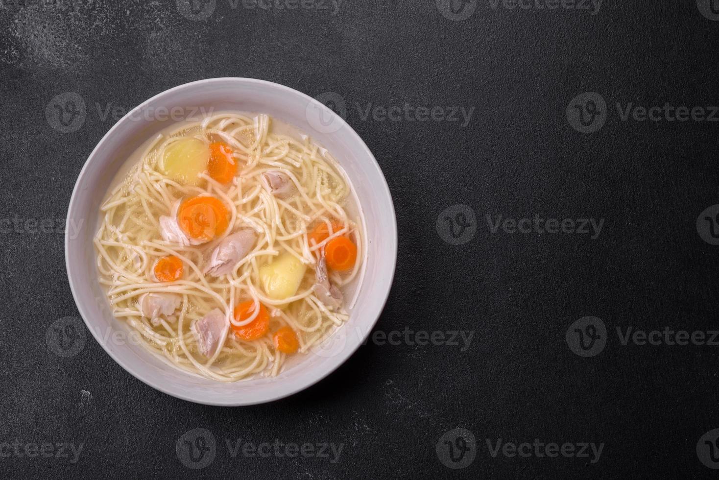 Delicious soup with noodles, chicken and carrots with spices and herbs photo
