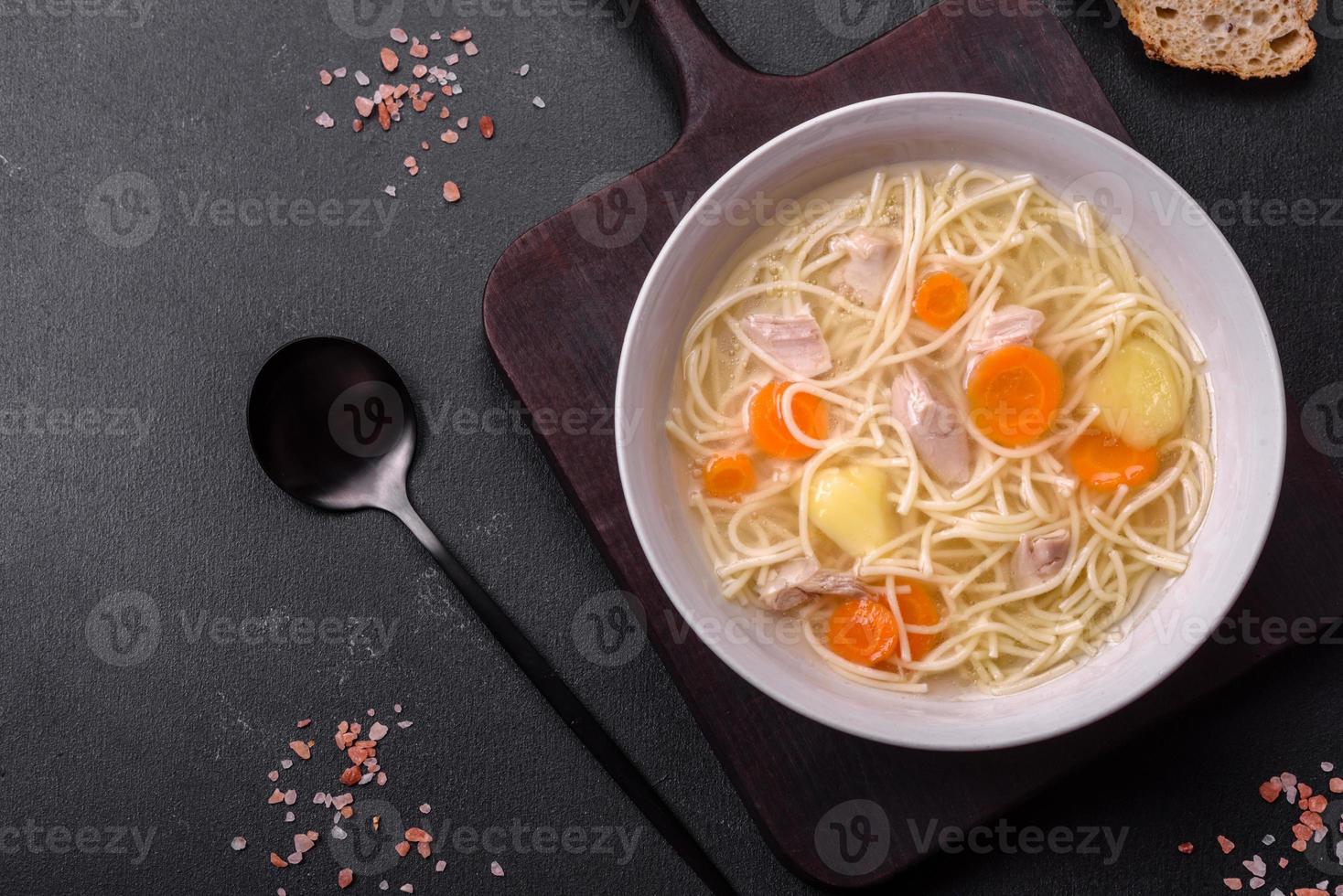 Delicious soup with noodles, chicken and carrots with spices and herbs photo