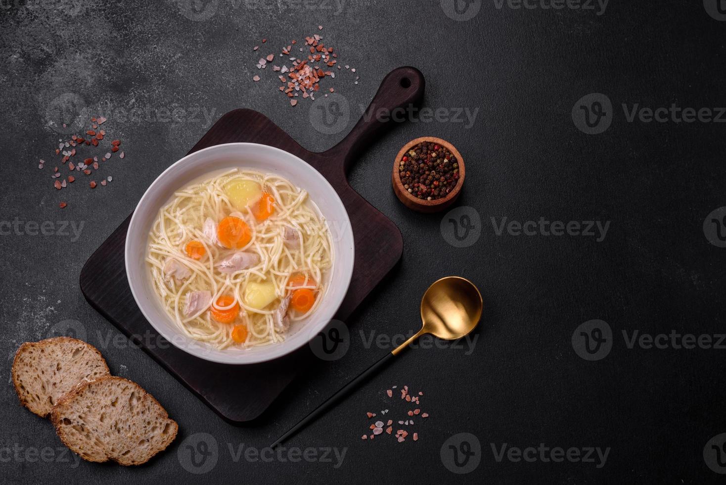 Delicious soup with noodles, chicken and carrots with spices and herbs photo
