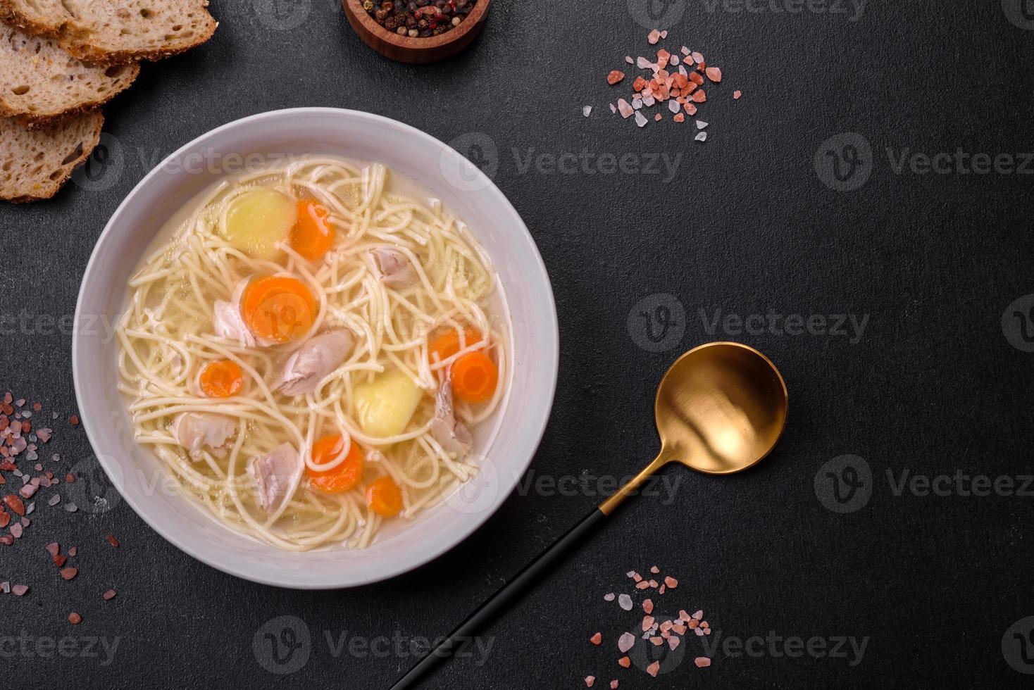 Delicious soup with noodles, chicken and carrots with spices and herbs photo