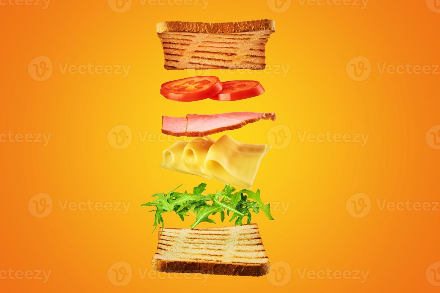 Fresh sandwich with flying ingredients on yellow background isolated photo
