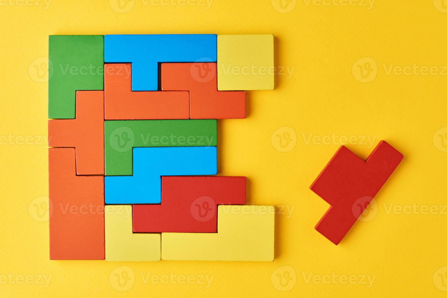 Different shapes colorful wooden blocks on yellow background photo