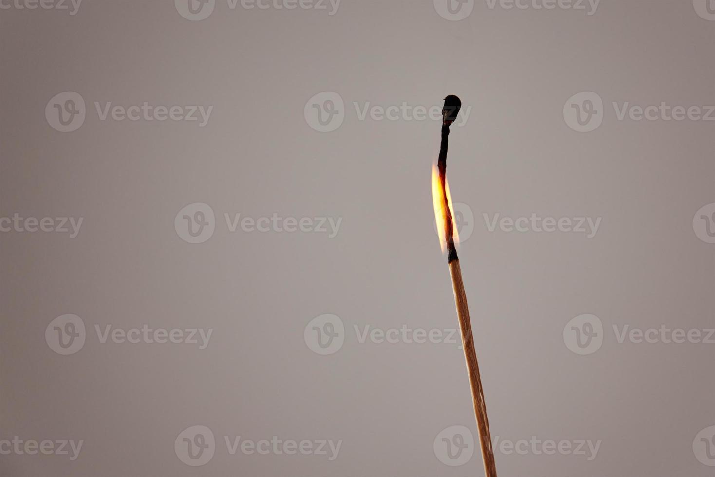 Burning matchstick on dark background. photo