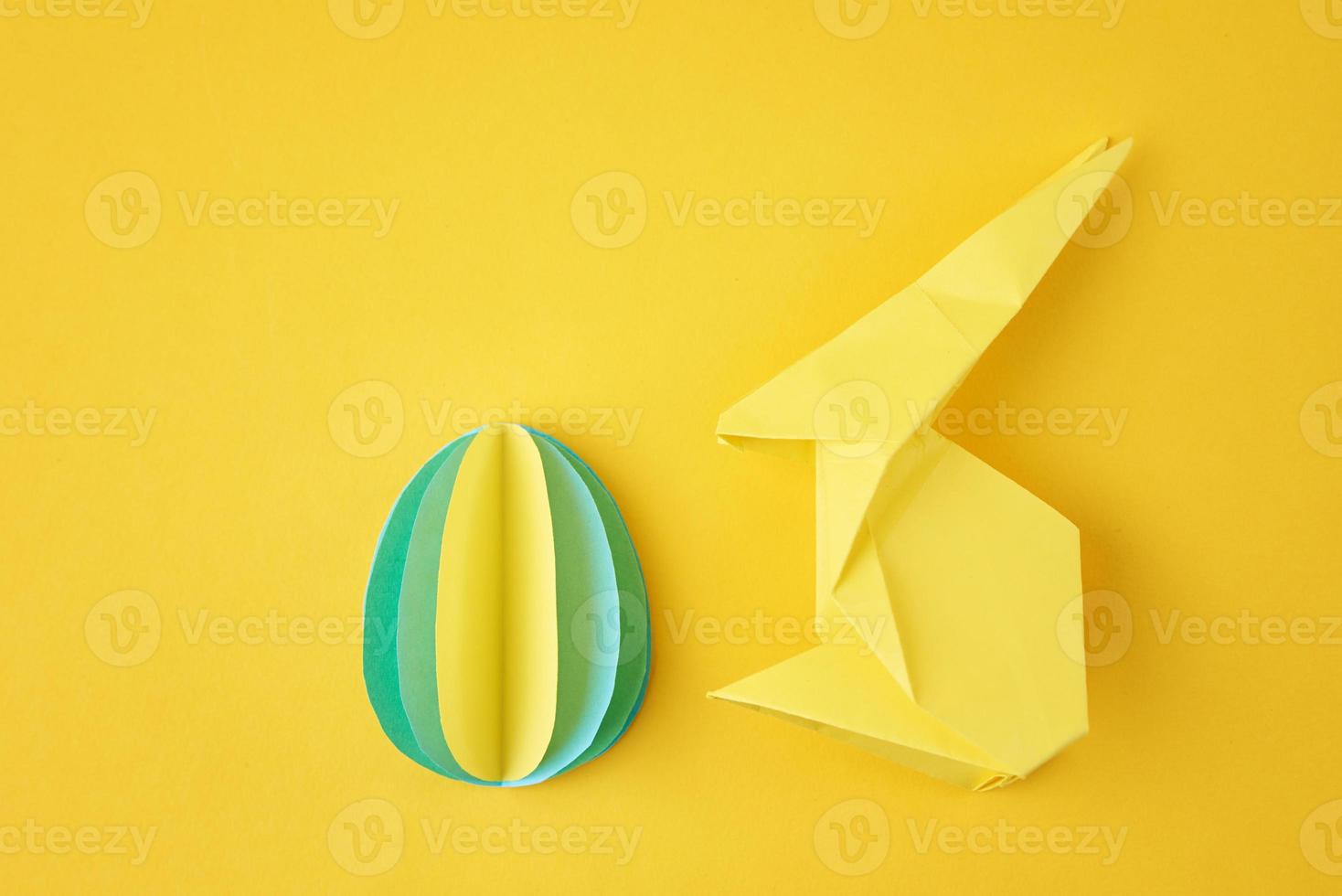 origami de papel eseter conejo y huevo de color sobre el fondo amarillo foto