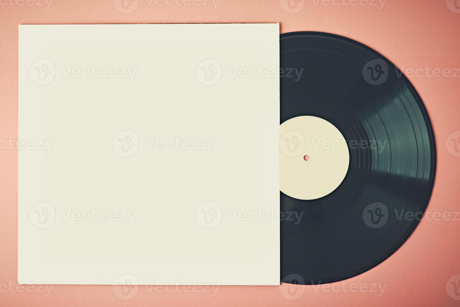 Old retro vinyl disc in paper case on pink background, mockup. Vintage toned photo