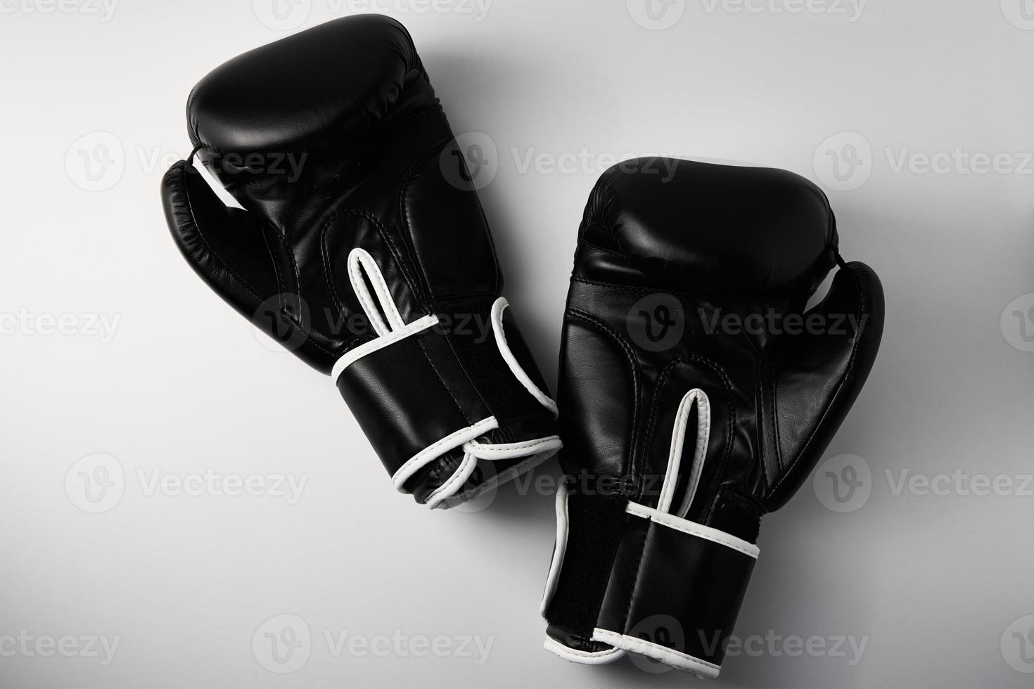 Pair of black boxing gloves on white background, closeup photo