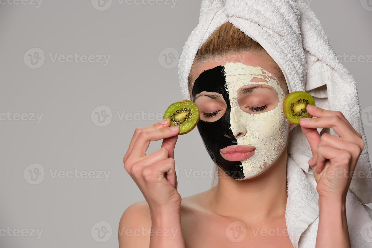 beautiful female model with black and white facial cosmetic mask photo