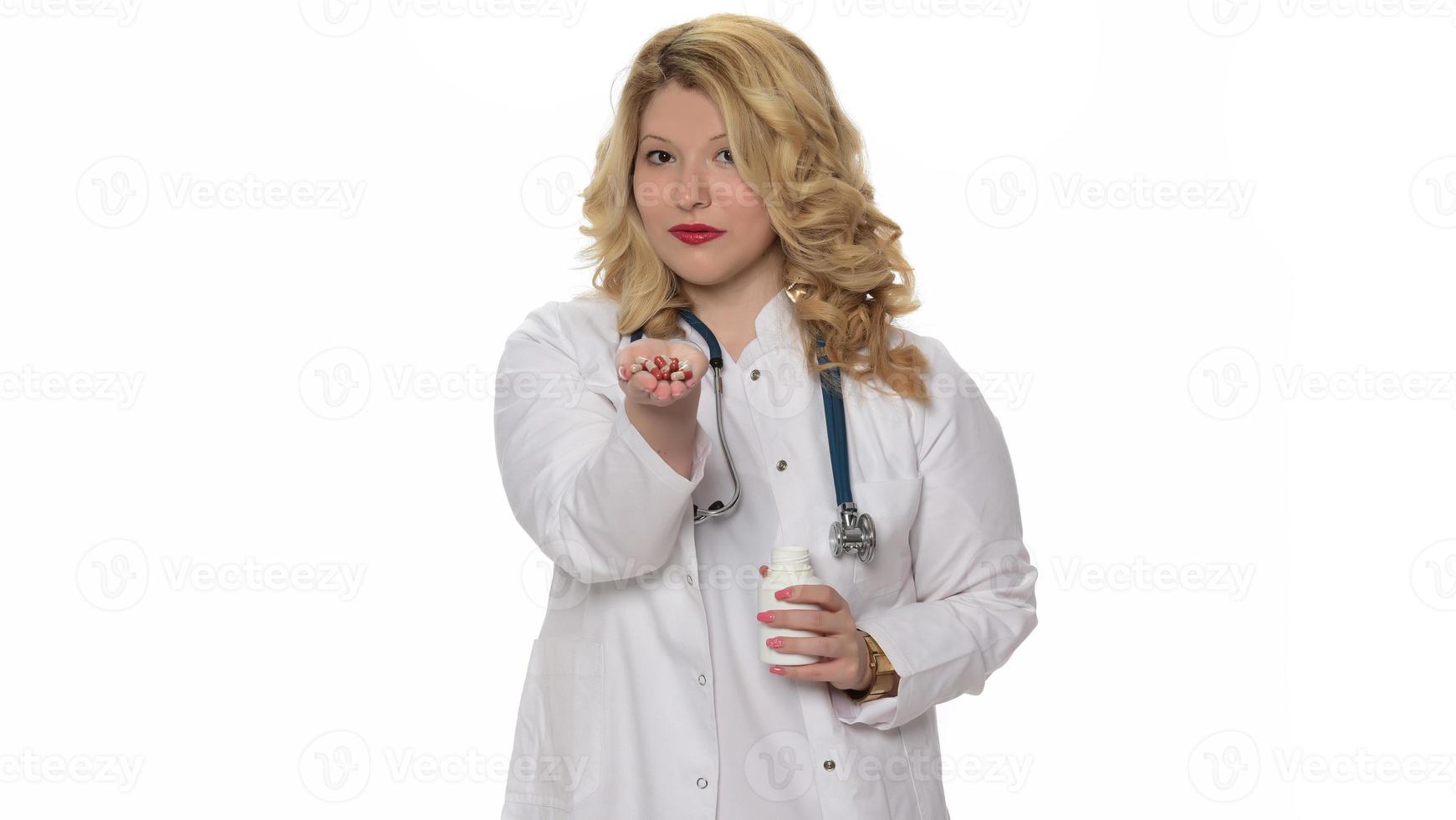 Smiling female pharmacist holding a pill, health care and prevention concept, hand close up photo