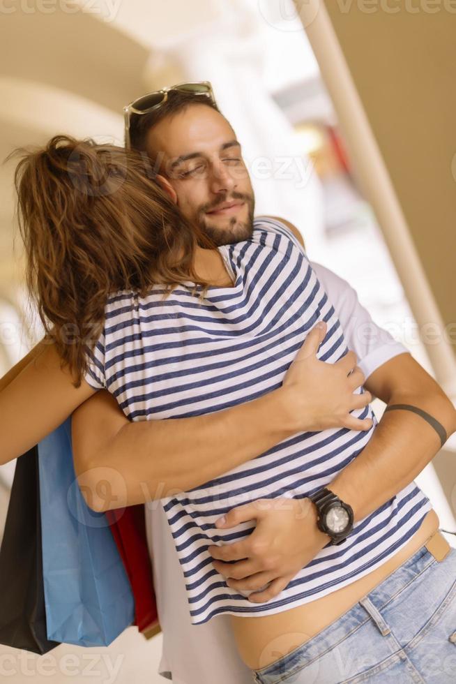 Portrait of cheerful Caucasian young couple man and woman holding many paper bags after shopping while walking and talking on street. Happy family couple with packages outdoor. Buying concept photo