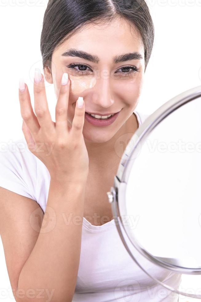 Woman doing make up, looking at mirror. photo