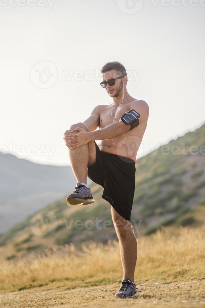 Athletic young man stretching after run in the nature. sport concept  16633108 Stock Photo at Vecteezy