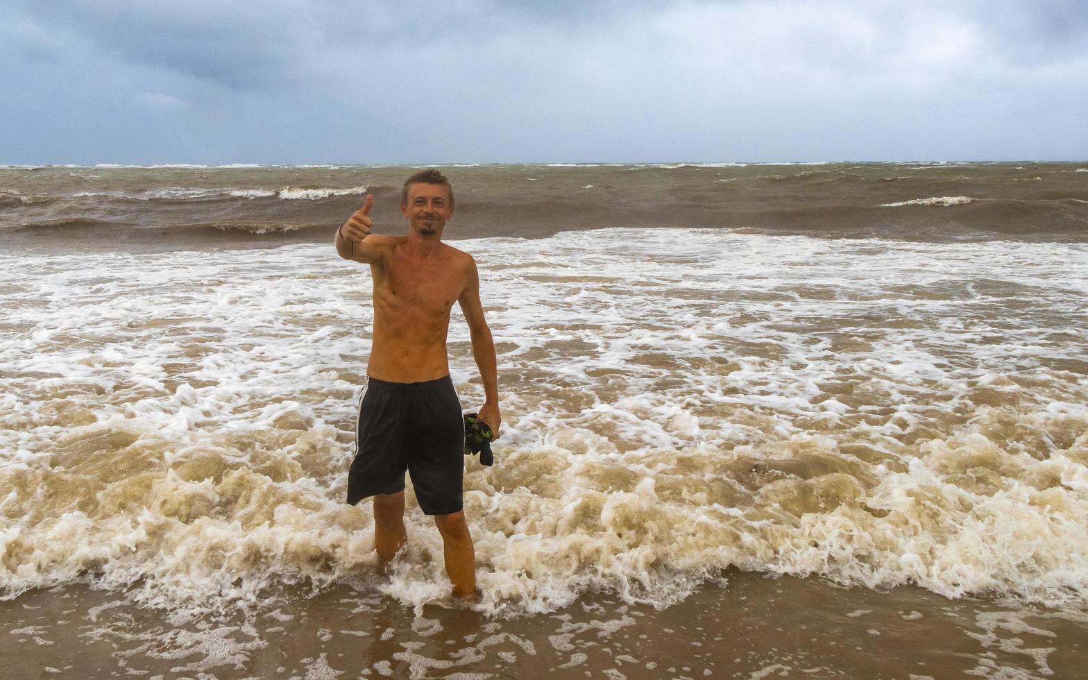 el hombre está en la playa durante el huracán y disfruta de México. foto