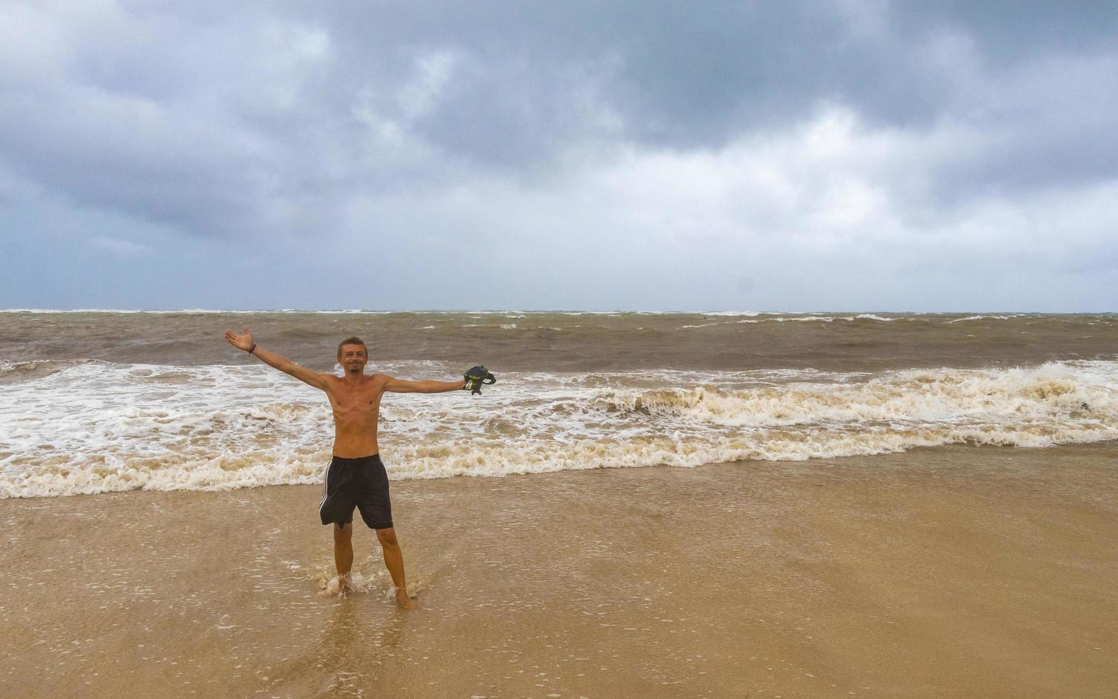 el hombre está en la playa durante el huracán y disfruta de México. foto