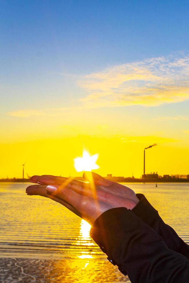 Sunset in the heart formed from hands in Germany. photo