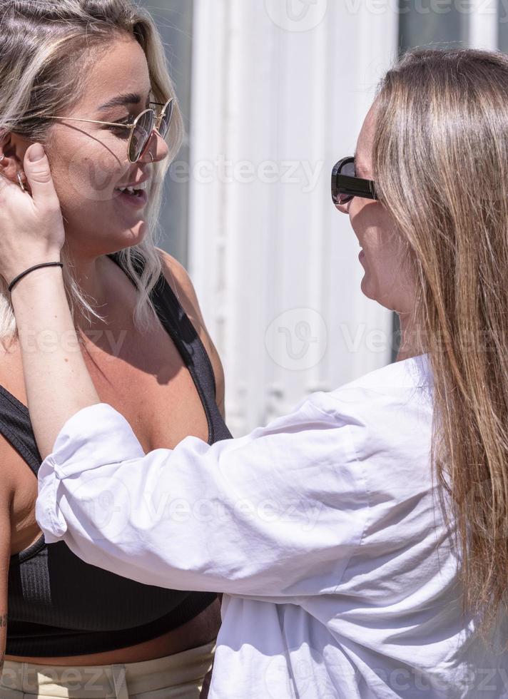 un par de mujeres gay sonriendo y besándose. pareja de mujeres jóvenes casadas del mismo sexo en su rutina diaria mostrando algo de afecto lgbt foto