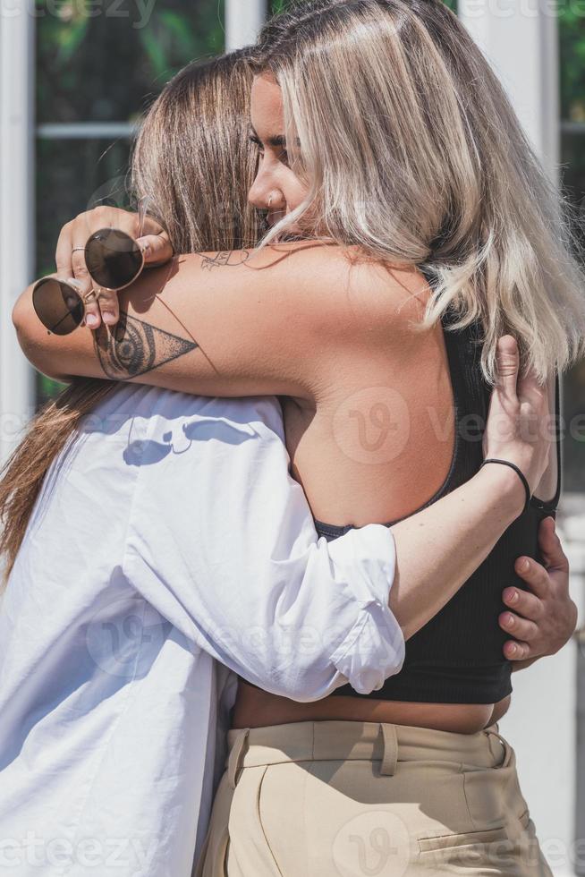 un par de mujeres gay sonriendo y besándose. pareja de mujeres jóvenes casadas del mismo sexo en su rutina diaria mostrando algo de afecto lgbt foto