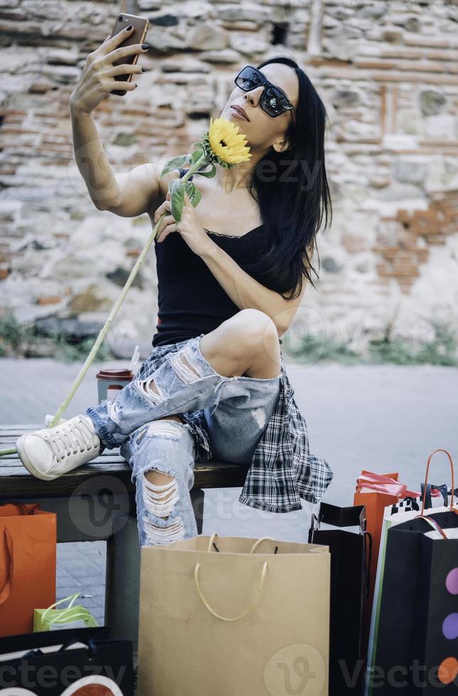 linda chica tomando selfie con bolsas de compras foto