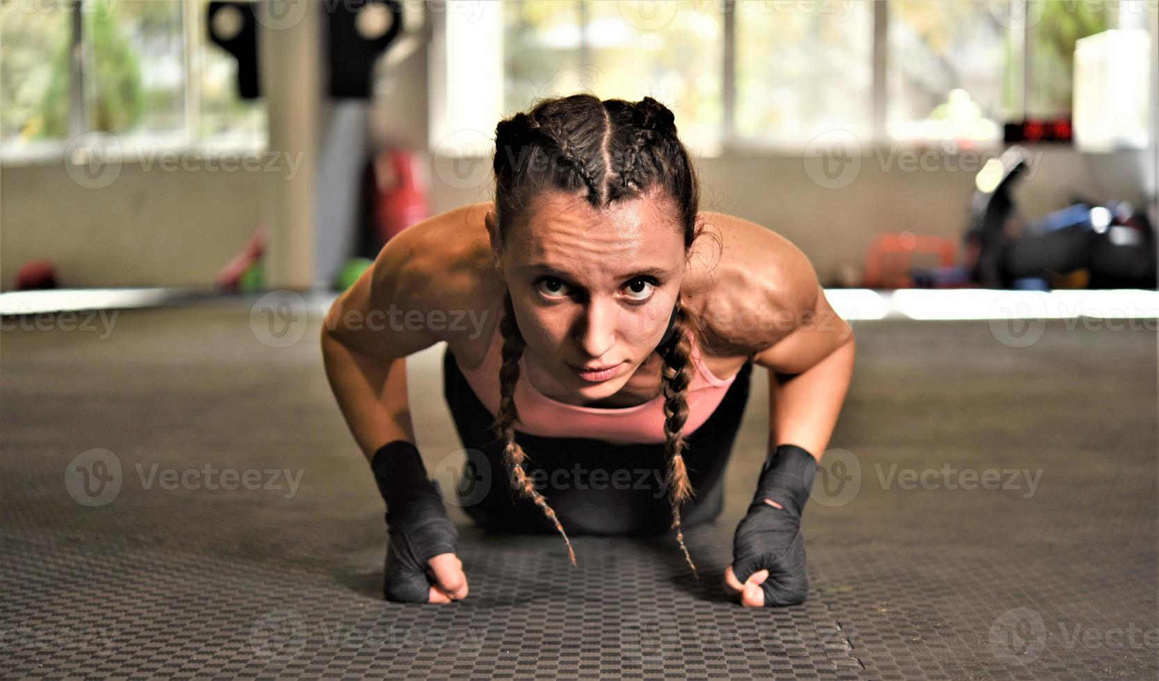 Woman on boxing training doing push ups photo