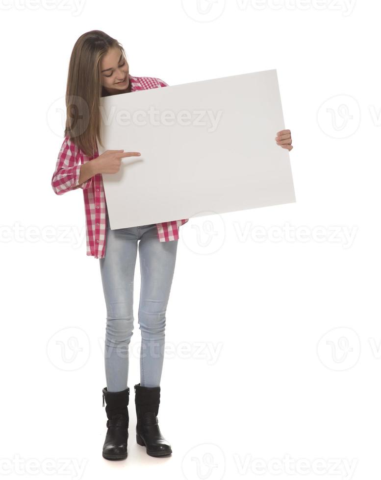 young smiling woman holding a blank sheet of paper for advertising photo