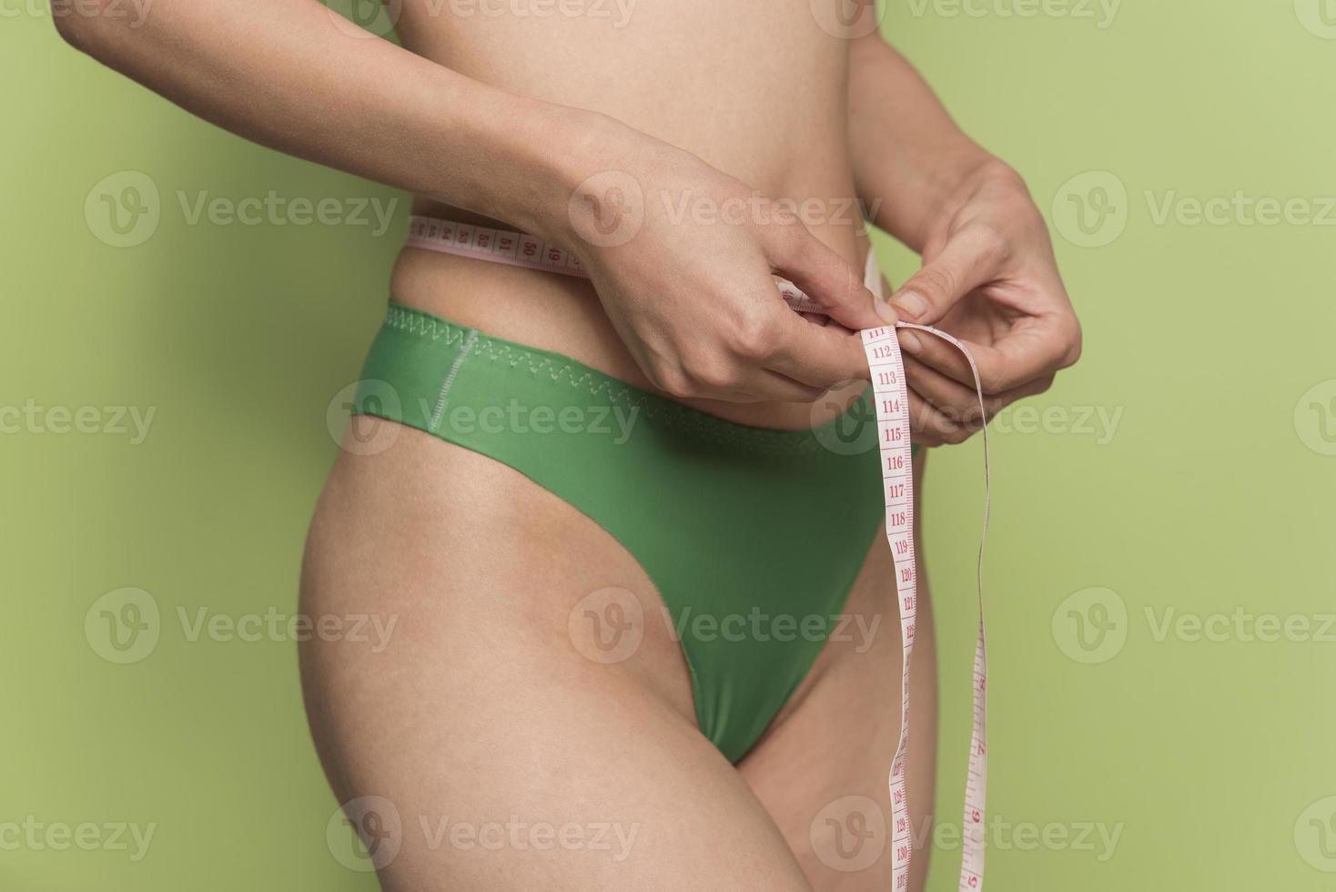 girl measures her volumes with a measuring tape. healthy and beautiful body. Female body, slim waist photo