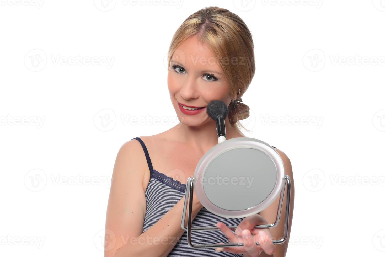 Image of joyful woman smiling at camera and using makeup brush photo