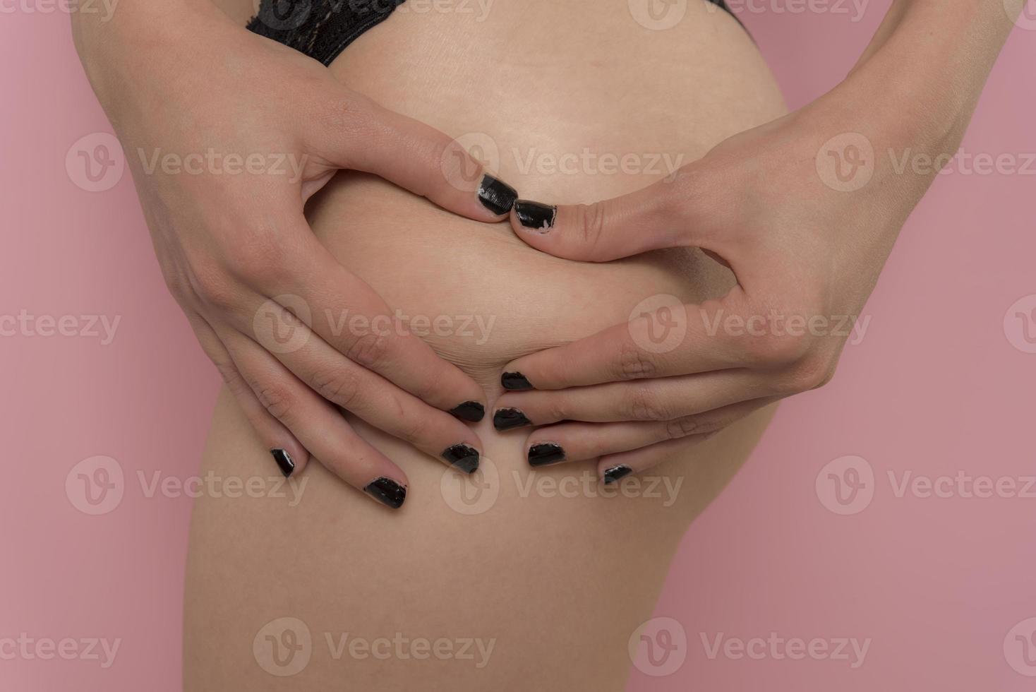 young woman checking her cellulite on her buttocks photo