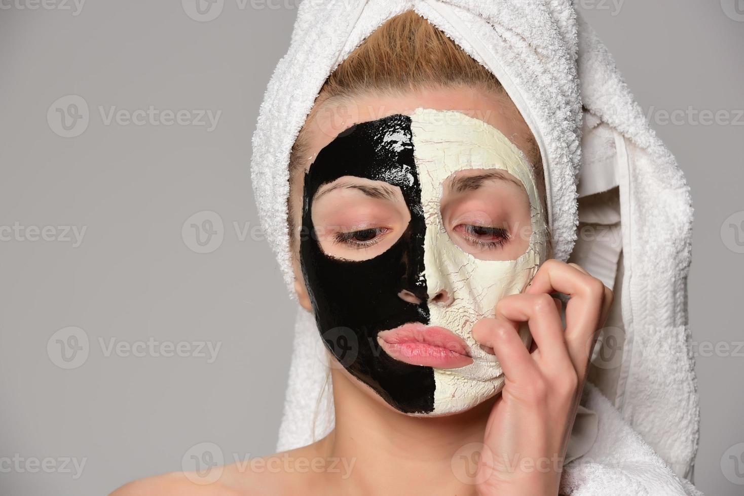 beautiful female model with black and white facial cosmetic mask photo