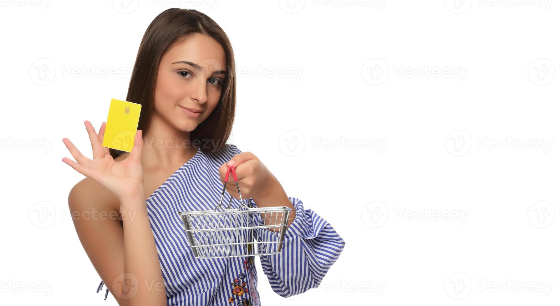 Credit card in a woman's hand and a small souvenir cart. Shopping, wholesale and retail trade, discounts, purchases on credit, credit history. photo