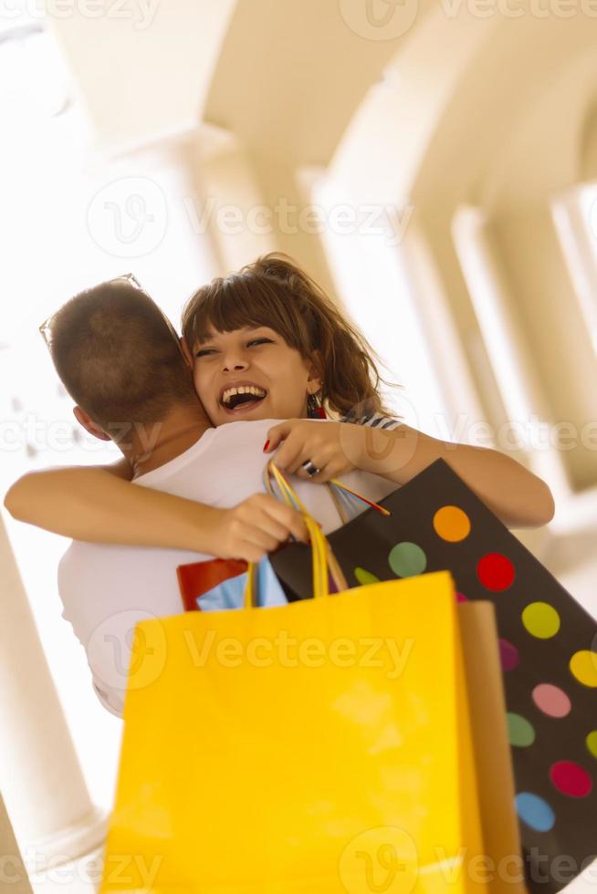 Portrait of cheerful Caucasian young couple man and woman holding many paper bags after shopping while walking and talking on street. Happy family couple with packages outdoor. Buying concept photo