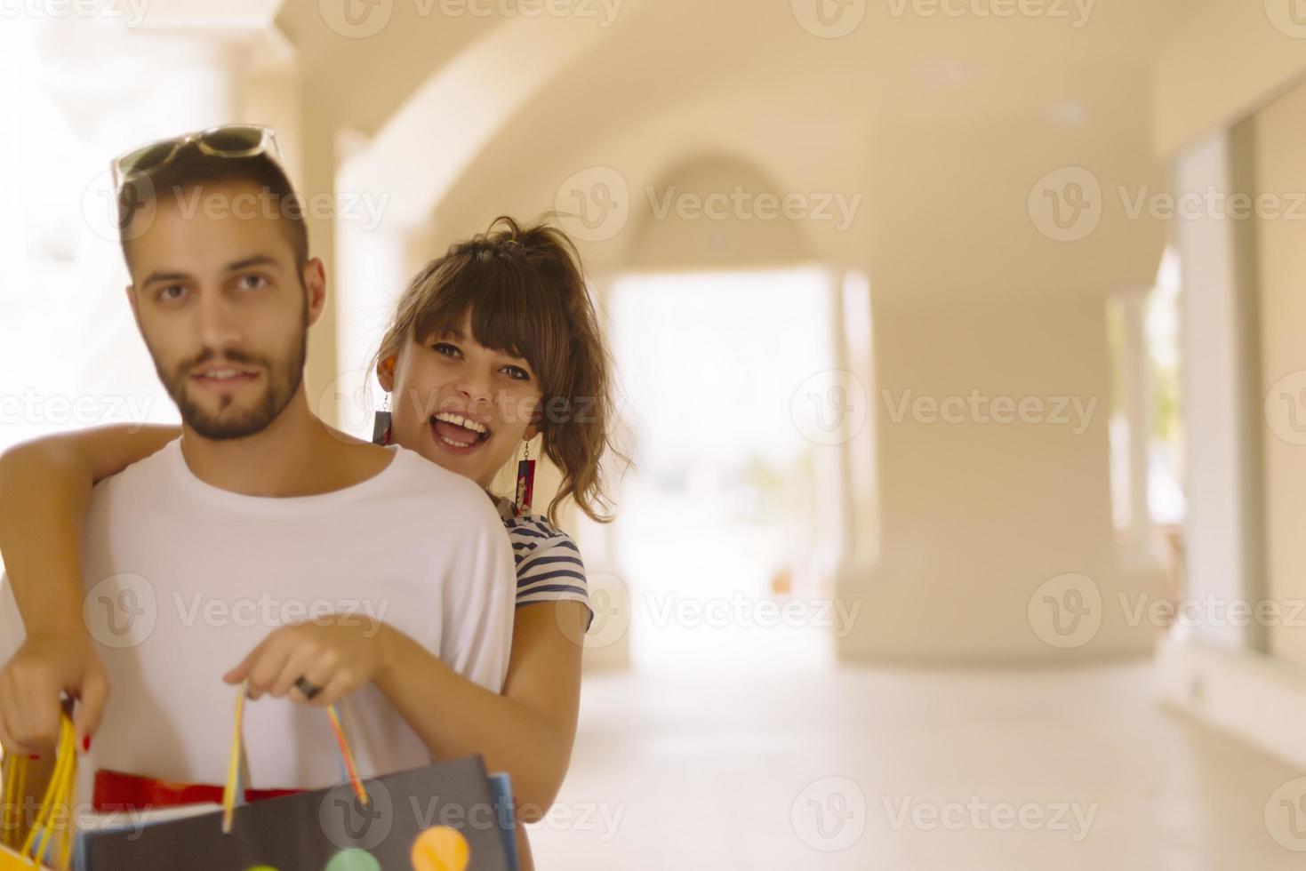 Portrait of cheerful Caucasian young couple man and woman holding many paper bags after shopping while walking and talking on street. Happy family couple with packages outdoor. Buying concept photo