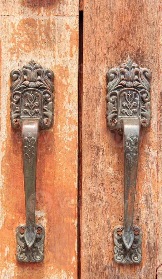 Brown wooden door has a key and a lock and a handle for locking the door to prevent thieves and thieves from stealing your belongings and valuables. It is an ancient wooden door photo
